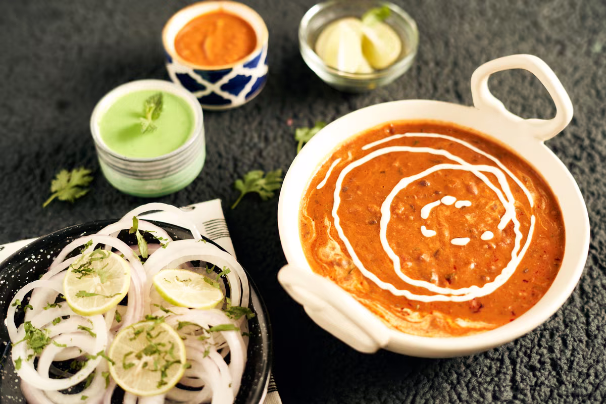 Dal makhani v bílé misce s cibulí a chutney, fotografie, avif