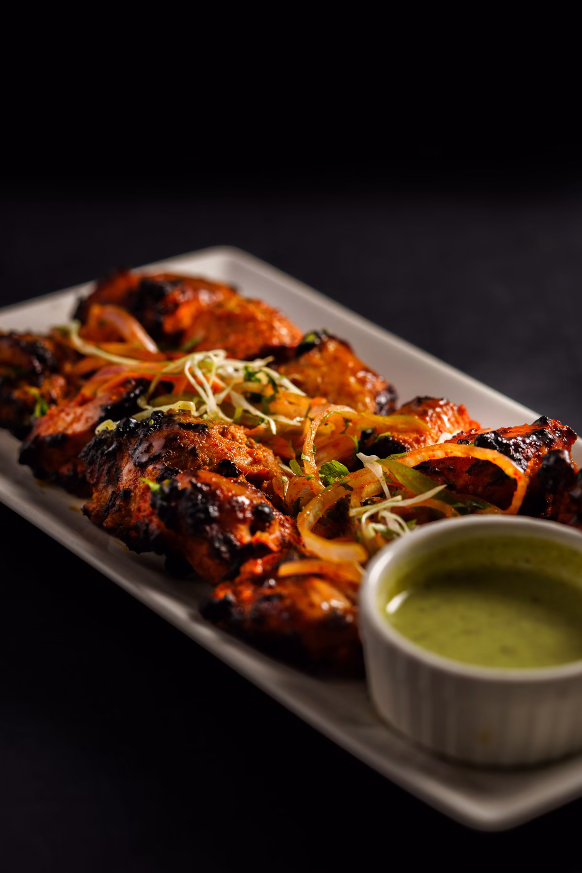 Tandoori kuře na podlouhlém talíři s mátovým chutney, fotografie, avif